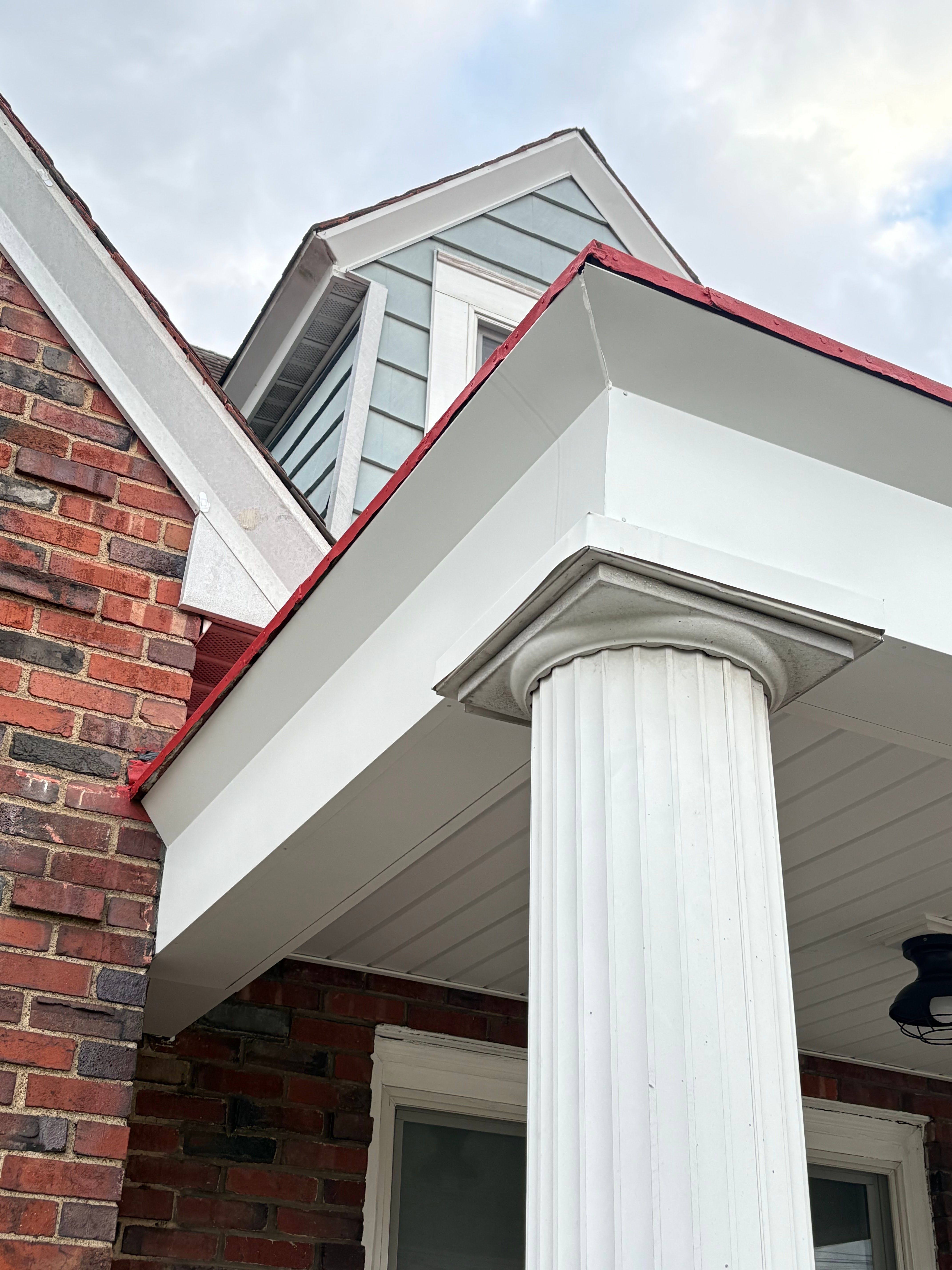 White porch column and finished soffit against brick