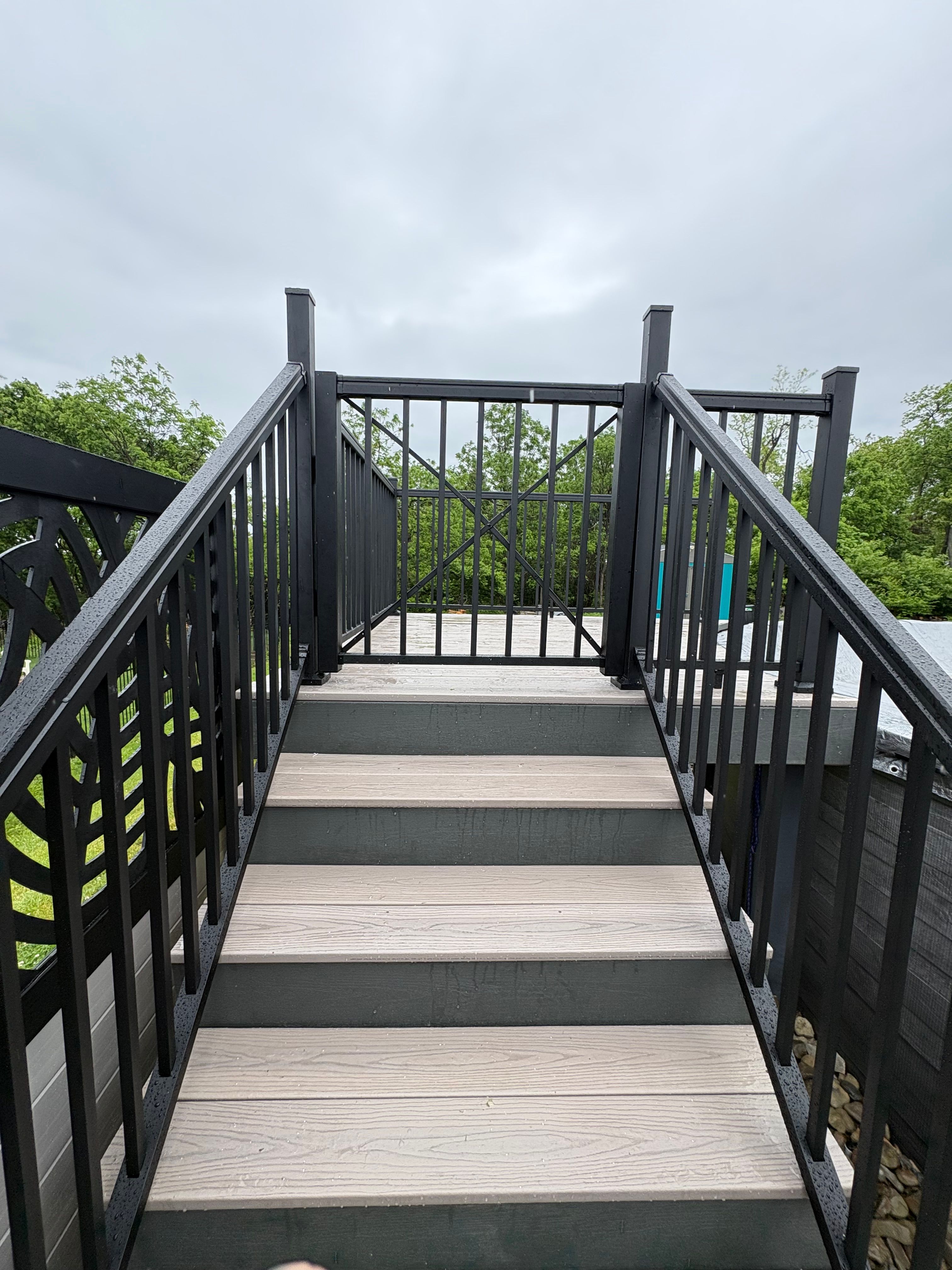 Composite steps rising between black aluminum railings