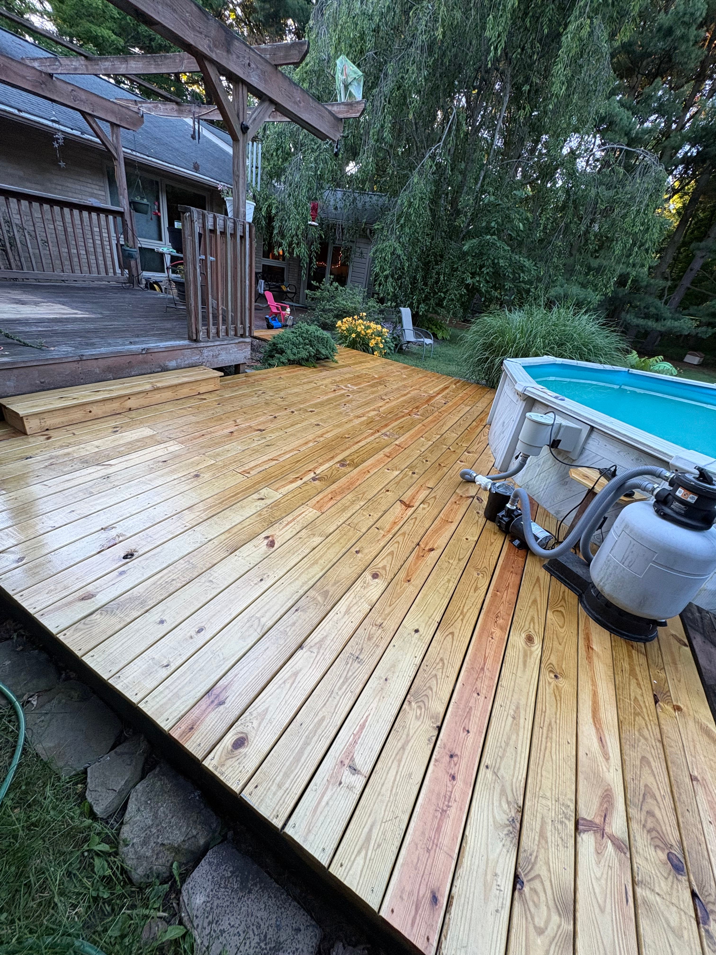 New pressure treated deck built alongside an above ground pool