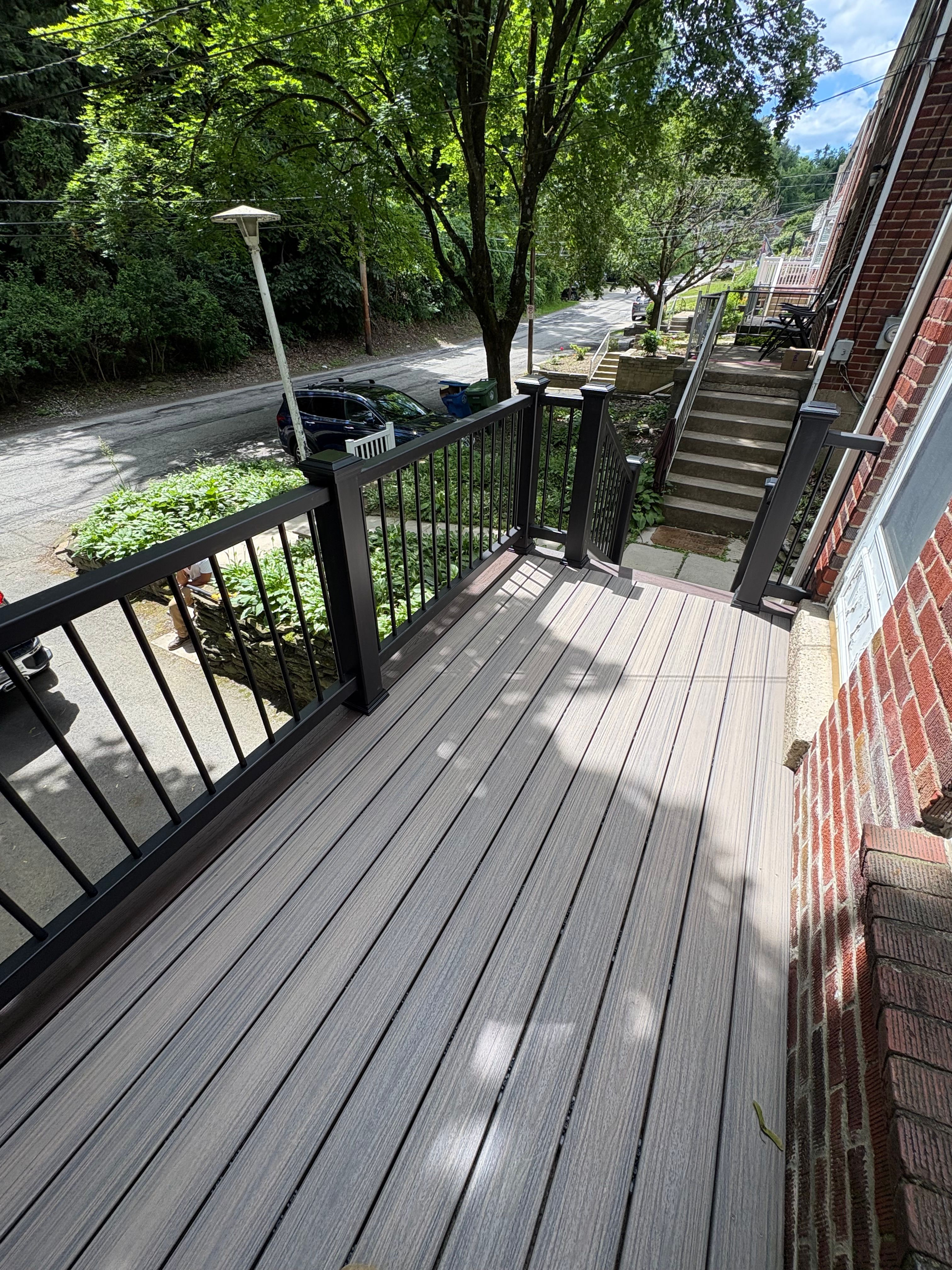Grey composite deck with black railing overlooking the street