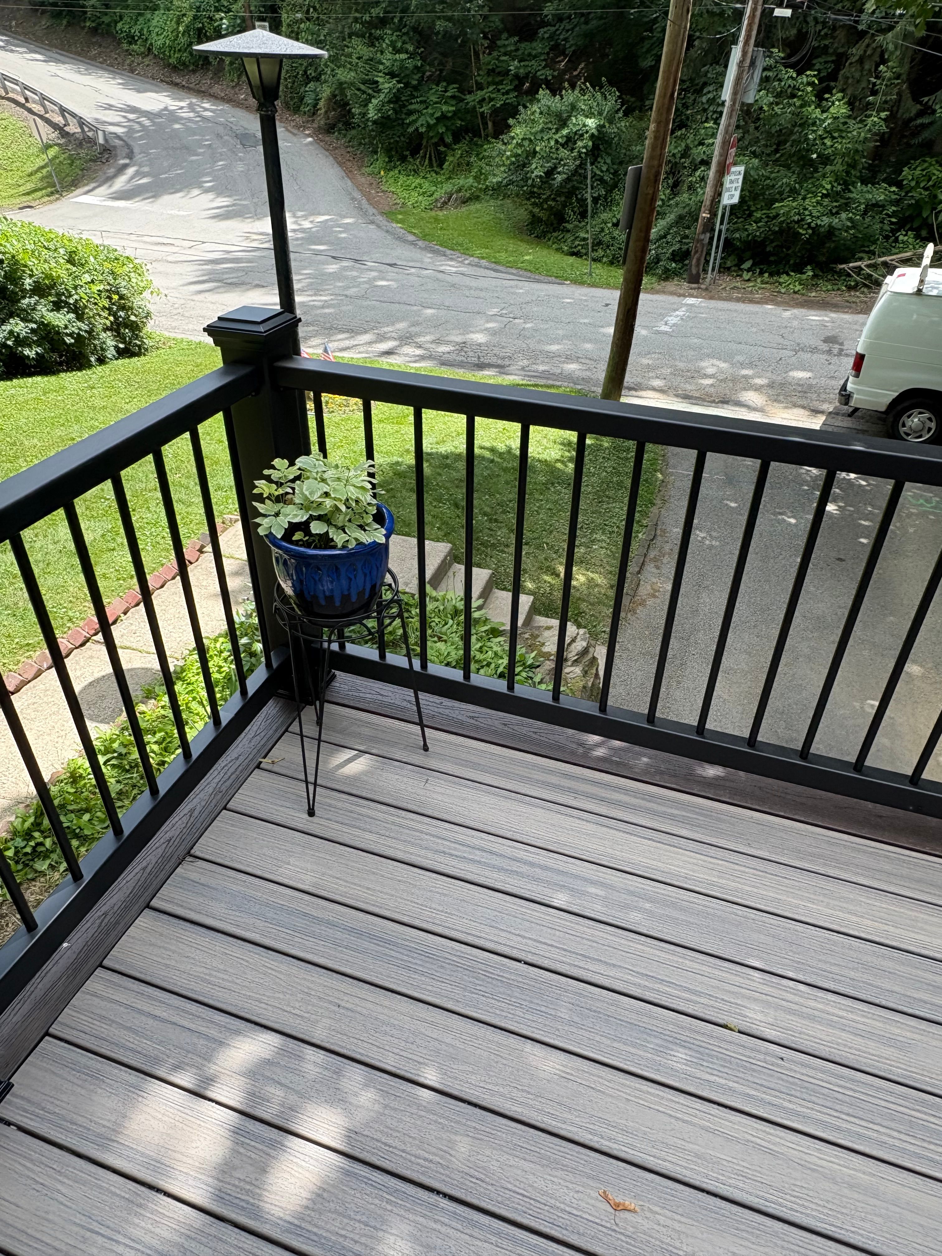 Corner of a grey composite deck with black railing