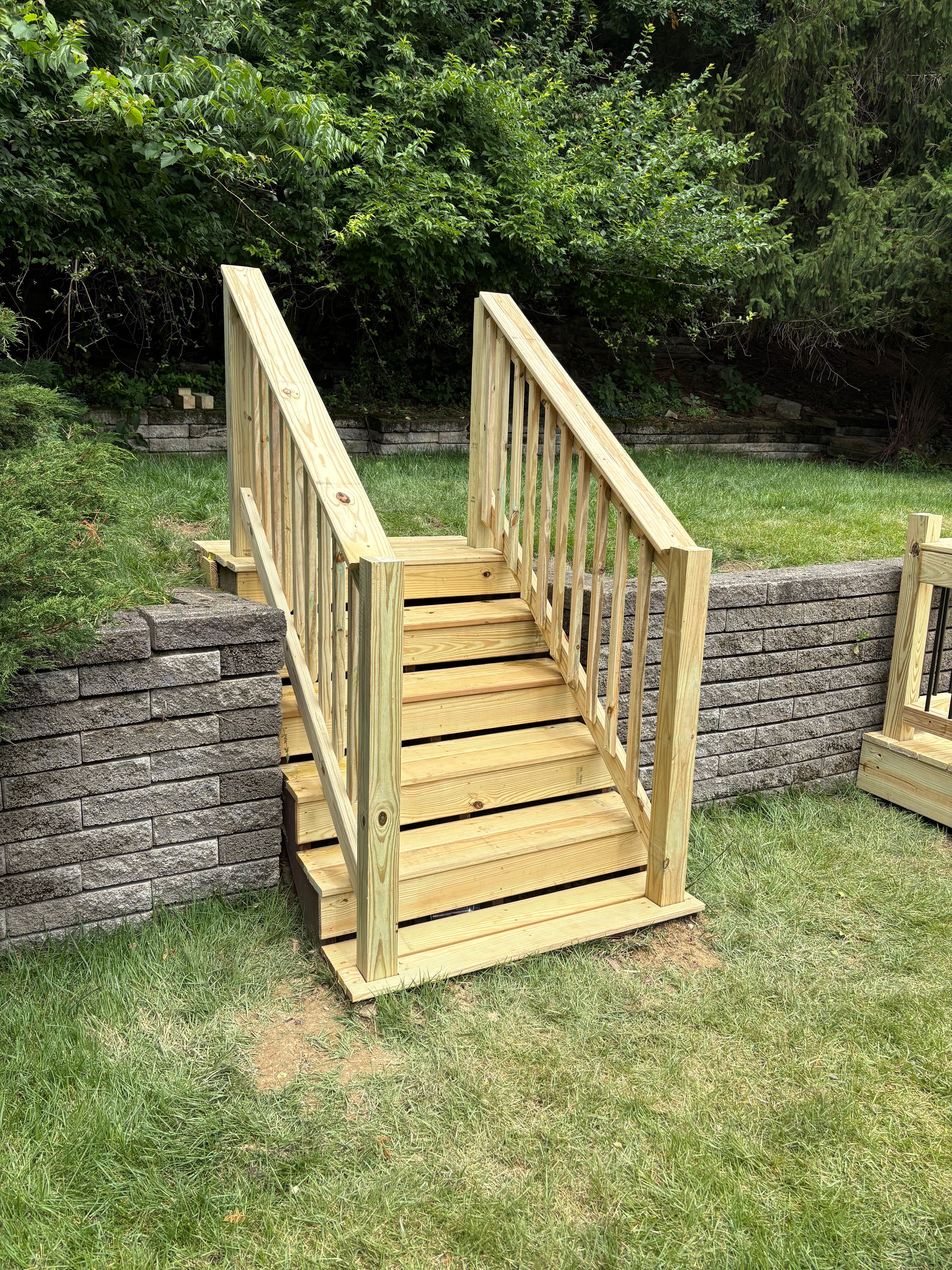 New pressure treated steps beside a block retaining wall