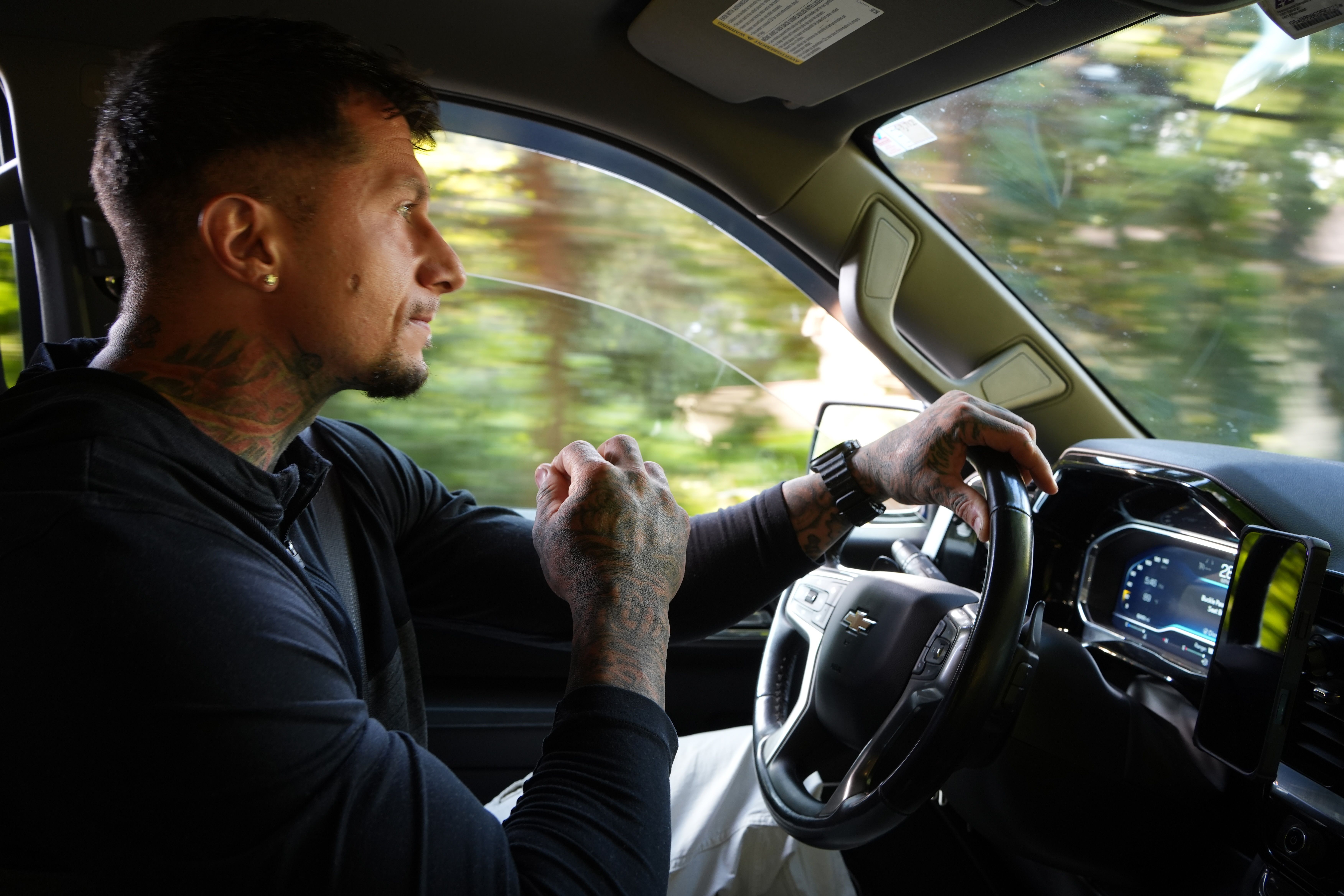 Anthony driving a pickup, one hand on the wheel, looking ahead