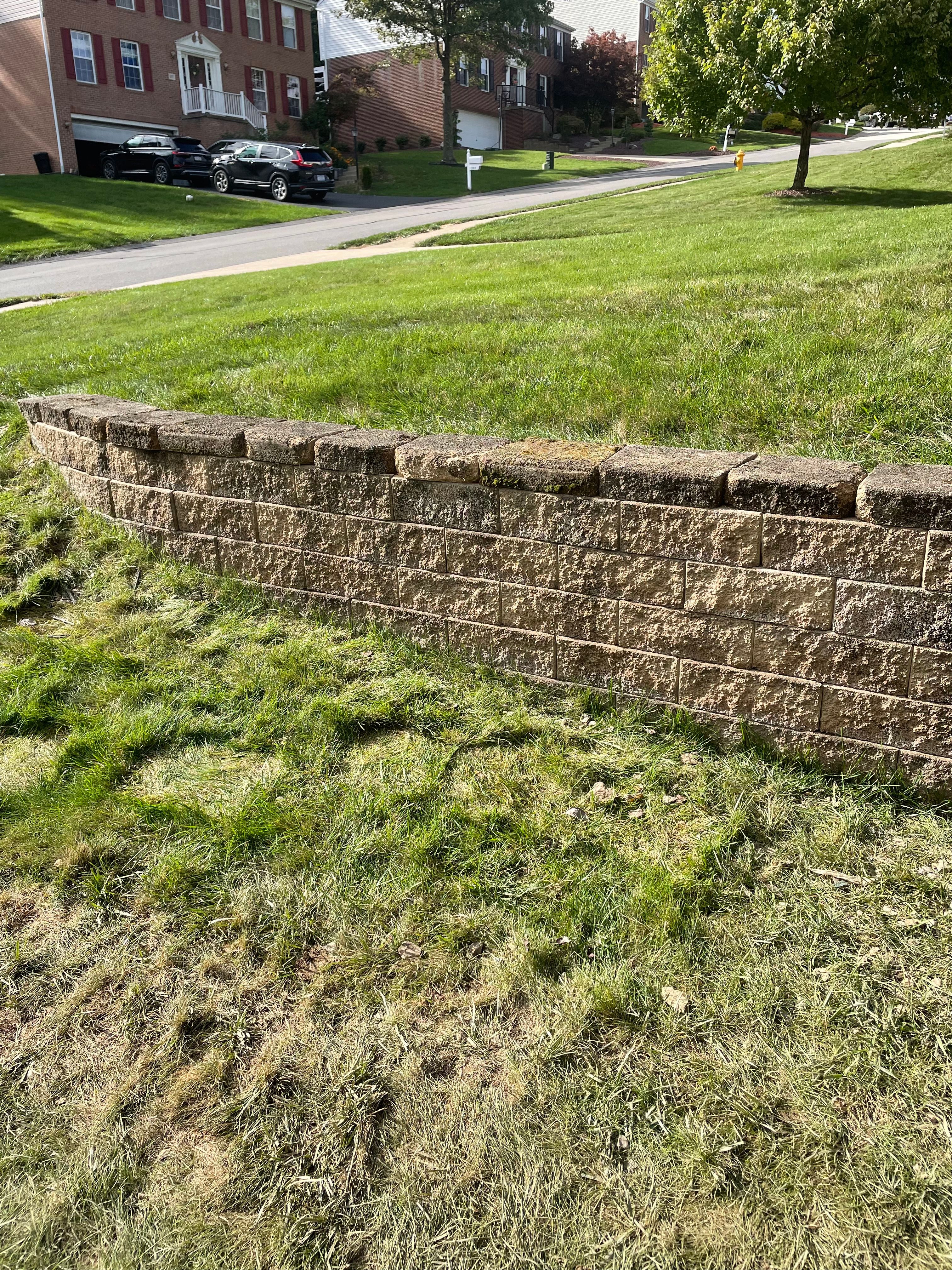 Block retaining wall running along a lawn