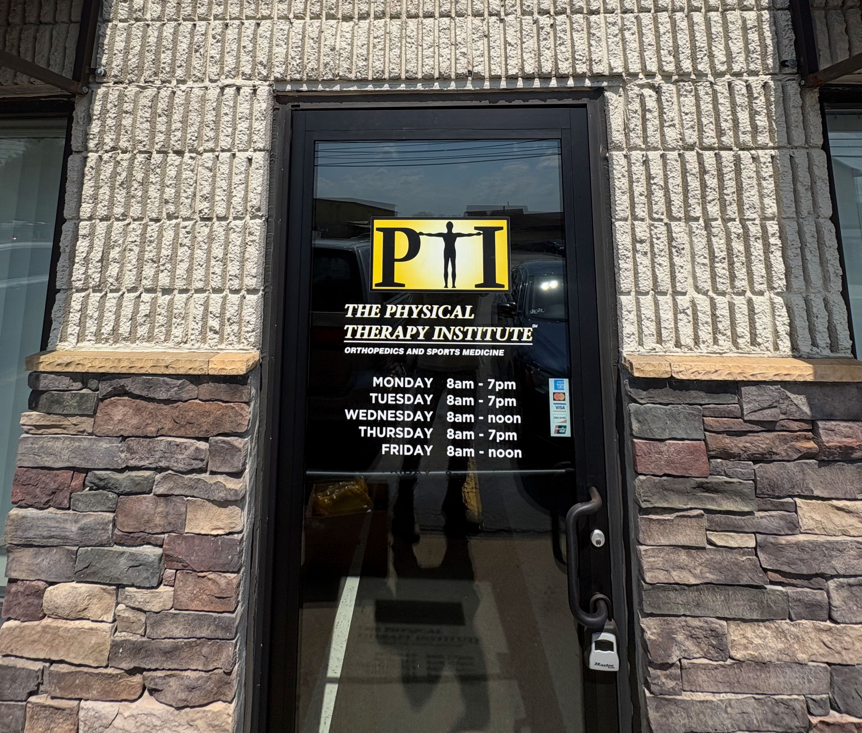 A newly installed glass entry door set into a stone facade.